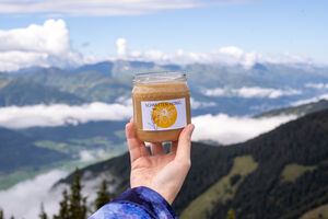 Ein Glas Schmitten-Honig vor traumhaftem Bergpanorama