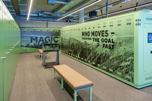 A modern locker room with green lockers and benches. | © Nikolaus Faistauer Photography